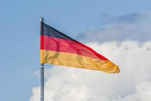 The National flag of Germany flay over the blue sky. Toned photo