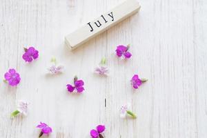 first day of July, colorful background with calendar, flowers photo