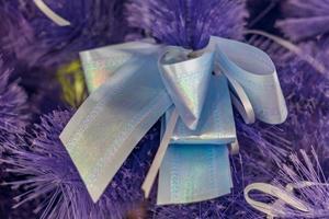 Closeup of Christmas-tree decoration. Decorative purple bow-knot in a fur tree photo