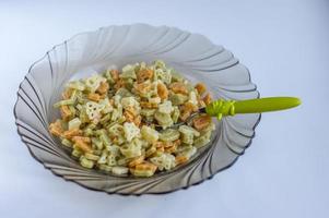 three colored pasta for kids in a plate with funny spoon photo