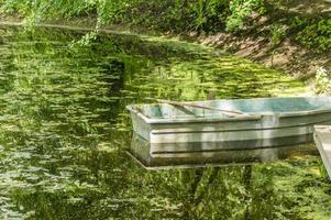 old green rowboat in a garden pond photo