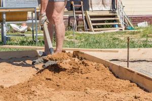 construction worker with a shovel, foundation preparation on construction site photo