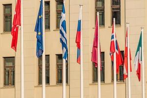 Colorful flags from different countries on building background photo