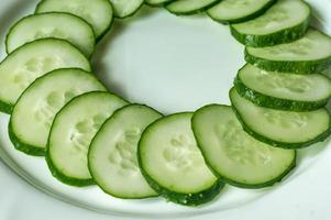 Multiple sliced cucumbers on a white plate photo