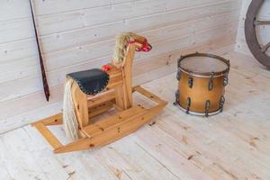 wooden rocking horse and vintage drum indoors photo