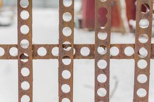 perforated fence on snow background. photo