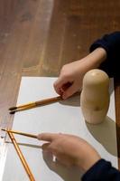 little boy is ready for painting matrioshka russian nesting doll photo