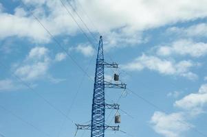 high voltage pole against blue cloudy sky photo