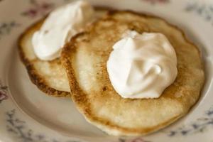 two pancakes with sour cream photo