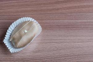 closeup of chocolate eclair on wooden table photo