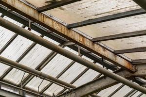 metal and glass roof of a greenhouse with pipes photo