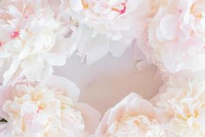 Beautiful blooming peony flowers on marble background. Trendy mockup with space for your design photo