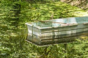 old green rowboat in a garden pond photo