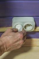 hand unplugging a plug from a socket photo