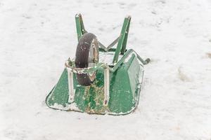 carretilla verde boca abajo sobre nieve blanca foto