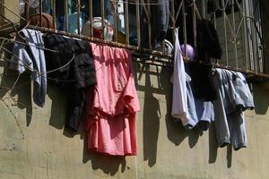 Washed linen dries on the street outside the window of the house. photo