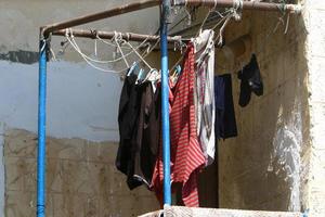 Washed linen dries on the street outside the window of the house. photo