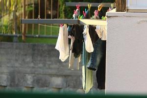 Washed linen dries on the street outside the window of the house. photo