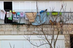 Washed linen dries on the street outside the window of the house. photo