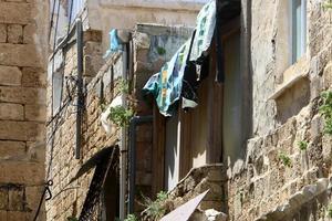 Washed linen dries on the street outside the window of the house. photo