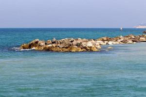 rompeolas en la playa de la ciudad para protegerse de las olas del mar. foto