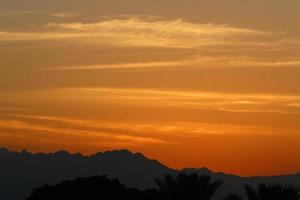 amanecer en el mar muerto en israel. el sol sale de detrás de las montañas en jordania. foto