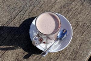 Hot and strong coffee is poured into a cup. photo