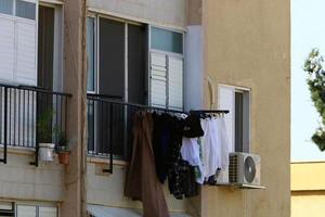 Washed linen dries on the street outside the window of the house. photo