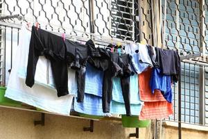 Washed linen dries on the street outside the window of the house. photo