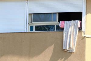 Washed linen dries on the street outside the window of the house. photo