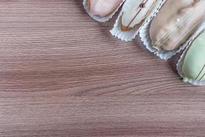 french eclairs on wooden table photo