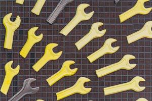 Set of yellow and brown wrenches hanging on the wall foe decoration photo