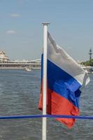 la bandera nacional de rusia ondea sobre el barco en el fondo de la ciudad de moscú. foto