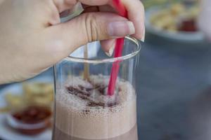 chocolate milk shake cocktail in woman hand on the open terrace summer time photo