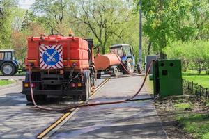 Máquinas barredoras de limpieza de calles que bombean agua para lavar carreteras asfaltadas foto