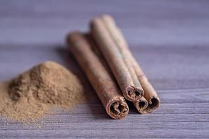 cinnamon sticks and powder on wooden table. toned photo