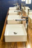 Row of wash sinks in public bathroom, closeup photo