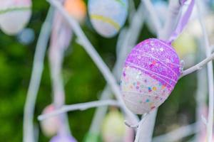 colorido huevo de Pascua colgando de la rama de un árbol, de cerca foto