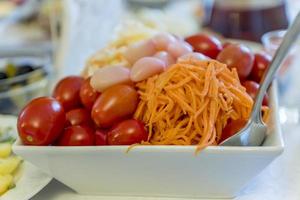 cuenco blanco con verduras en escabeche tomates, ajo, zanahoria foto