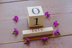 first day of July, colorful background with calendar and pink flowers photo