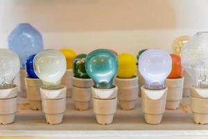 different colorful lightbulbs on shelf photo