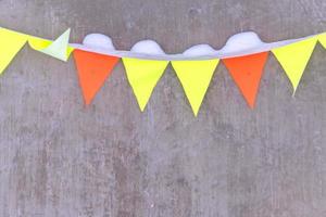 colorfull flags garland with snow on concrete wall background photo