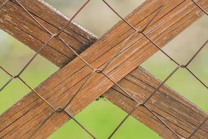 close up of chain link fence with wooden plank photo