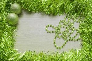 Christmas New Year holiday background. Green tinsel and two sparkle balls. Copy space photo