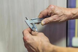 Sliding caliper measures the diameter of the screw. photo