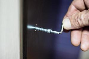 Assembling of furniture, closeup hex wrench in man hand photo