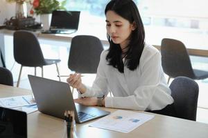 Female employees are working at home through computers to maintain social distancing to reduce the spread of coronavirus. photo