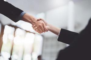 Asian entrepreneurs handshakes to congratulate the agreement between the two companies to enhance investment and financial strength. deal concept photo