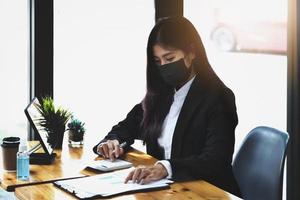 Business woman using calculator to review balance sheet annual  using  document and laptop computer to calculating budget. audit and Check integrity before investment concept. photo