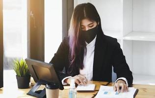 Business woman using calculator to review balance sheet annual  using  document and laptop computer to calculating budget. audit and Check integrity before investment concept. photo